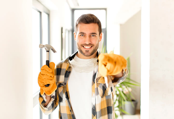 handyman wearing gloves and holding hammer